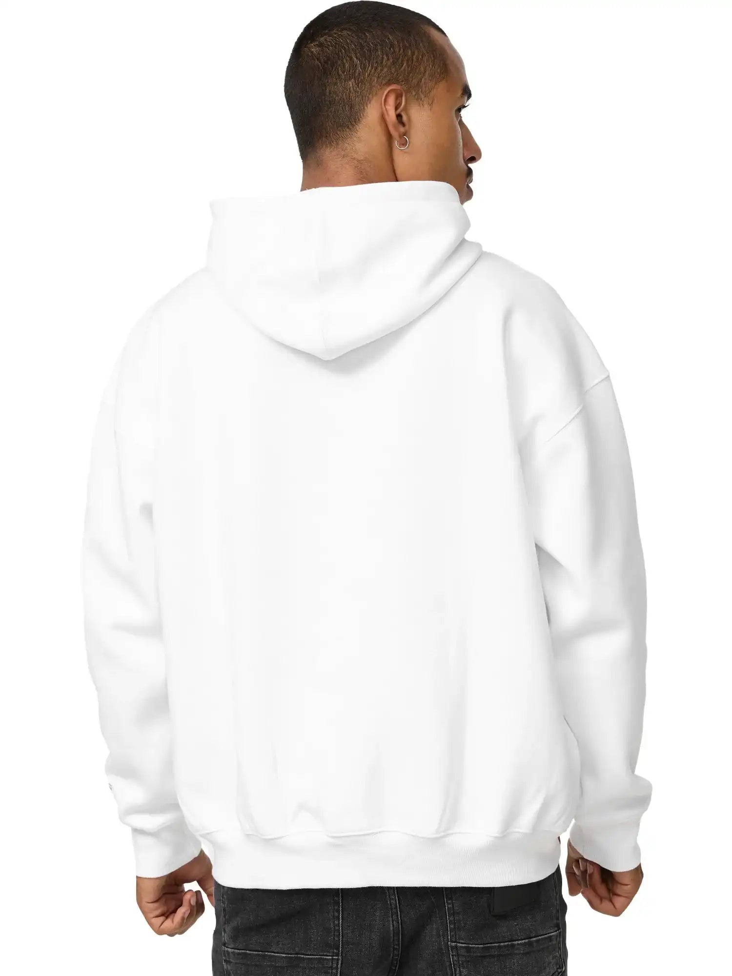 Eine Person blickt von der Kamera weg und trägt einen trueprodigy Tobi Oversized Hoodie mit Print und dunkle Jeans. Die Kapuze ist heruntergezogen, der Hintergrund ist einfarbig weiß.