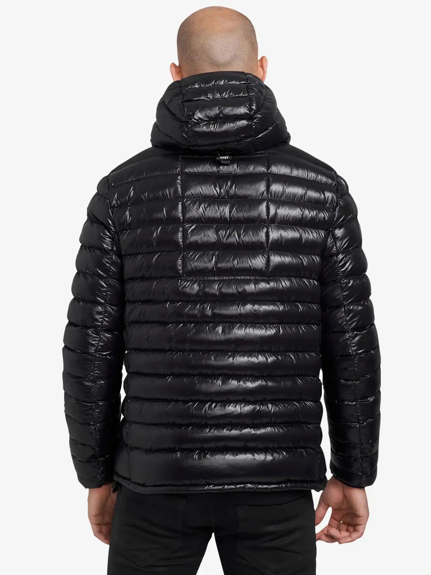 Von hinten ist eine Person mit Glatze zu sehen, die eine glänzende schwarze Trueprodigy Adan Steppjacke mit Kapuze mit horizontaler Steppung trägt. Die wasserabweisende Jacke hebt sich von dem schlichten weißen Hintergrund ab.