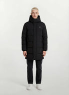 Eine Person mit kurzen blonden Haaren steht mit dem Gesicht nach vorne und trägt den trueprodigy Herren Parka mit fester Kapuze im Regular Fit, eine dunkle Hose und weiße Turnschuhe vor einem schlichten hellen Hintergrund.