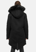 Eine Frau mit geflochtenem Haar ist von hinten zu sehen, die den trueprodigy Harvey F Damenparka mit Kapuze und Kunstfell mit spitzem Saum vor einem schlichten hellen Hintergrund trägt.