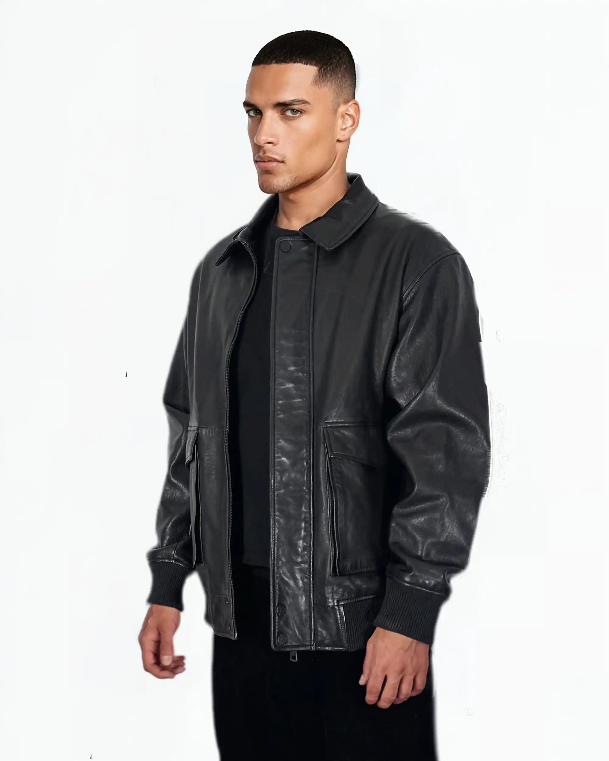 Ein Mann mit kurzen Haaren trägt die trueprodigy Ryder Oversize-Lederjacke mit Stehkragen, 3D-Silikonlogo & Retro-Details über einem schwarzen Hemd und einer Hose und steht leicht nach rechts gedreht vor einem schlichten weißen Hintergrund.