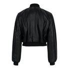 Eine schwarze, kurz geschnittene Lederjacke, die Bomber-Lederjacke für Damen „Paola“ mit Stehkragen von trueprodigy, wird von hinten vor einem schlichten weißen Hintergrund gezeigt. Sie verfügt über lange Ärmel, einen gerippten Bund und gerippte Ärmelbündchen, was ihren klassischen Bomber-Stil unterstreicht.