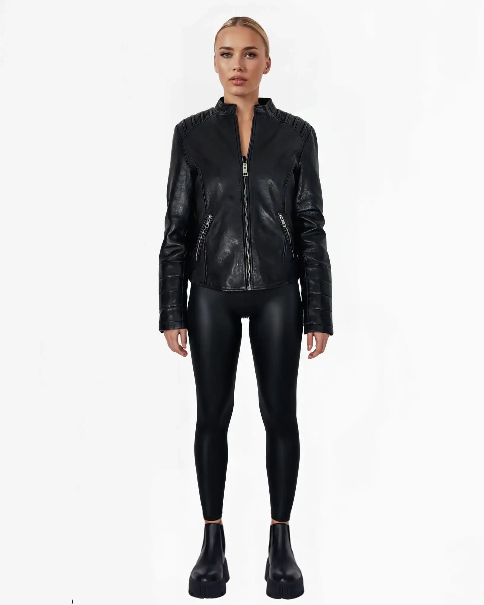 Eine Person trägt die "Raegan" taillierte Lederjacke mit Stehkragen, Steppnähten & silbernen Reißverschlüssen von trueprodigy, dazu glänzende Leggings und schwarze Chunky-Platform-Schuhe vor weißem Hintergrund.