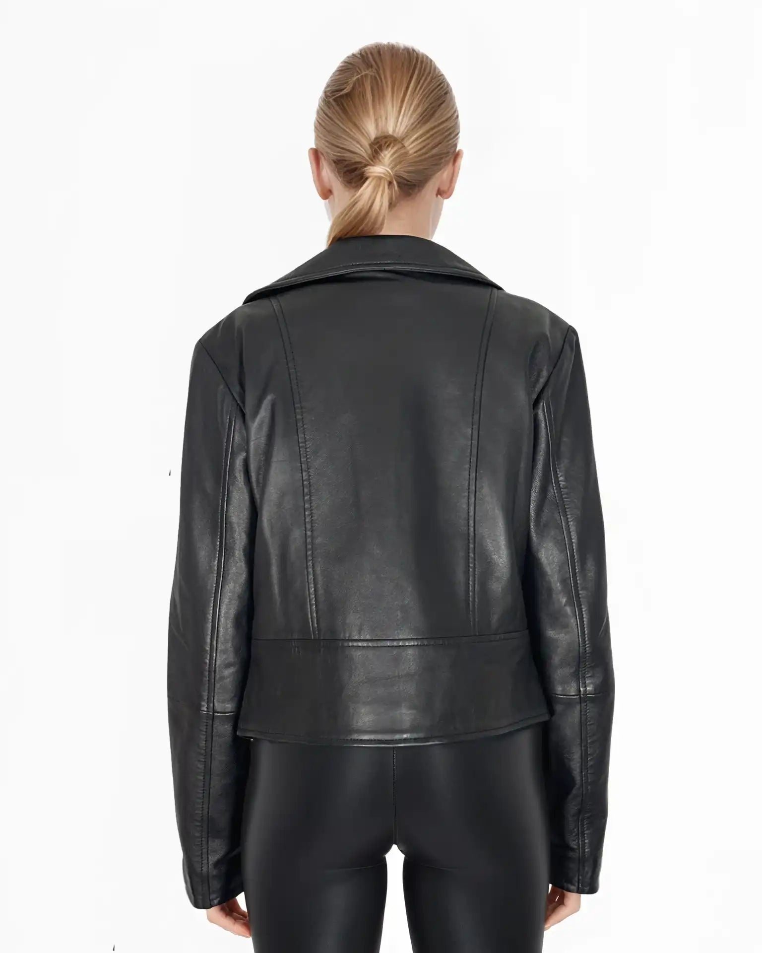 Eine Person mit blondem Haar in einem tiefen Dutt wird von hinten gezeigt, die die trueprodigy Stella taillierte Lederjacke mit schwarzem Reißverschluss & Ärmelzipper und eine schwarze Hose vor einem weißen Hintergrund trägt.