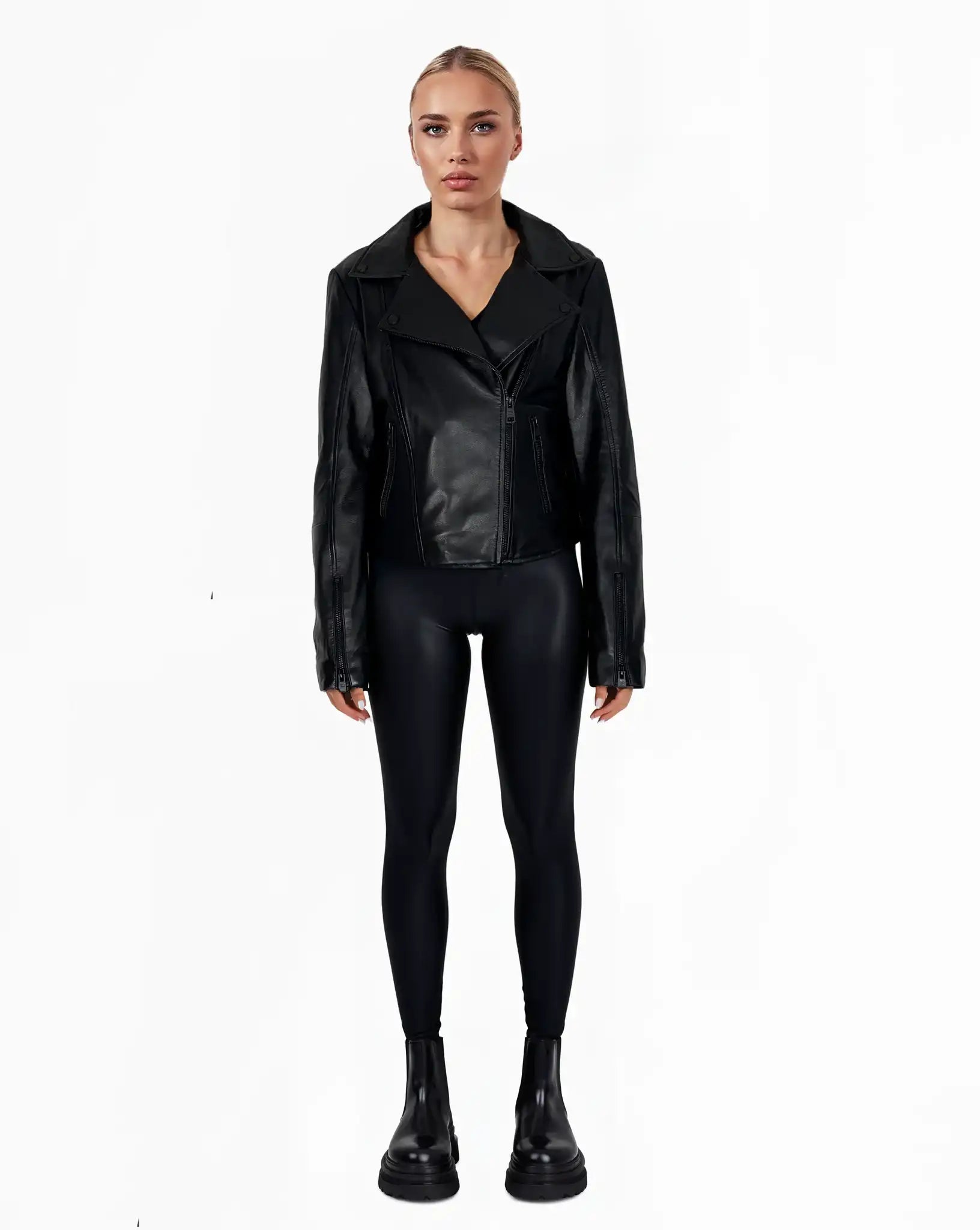 Eine Person steht mit dem Gesicht nach vorne und trägt die trueprodigy Stella taillierte Lederjacke mit schwarzem Reißverschluss & Ärmelzipper, schwarze Leggings und schwarze Ankle Boots. Der Hintergrund ist einfarbig weiß.