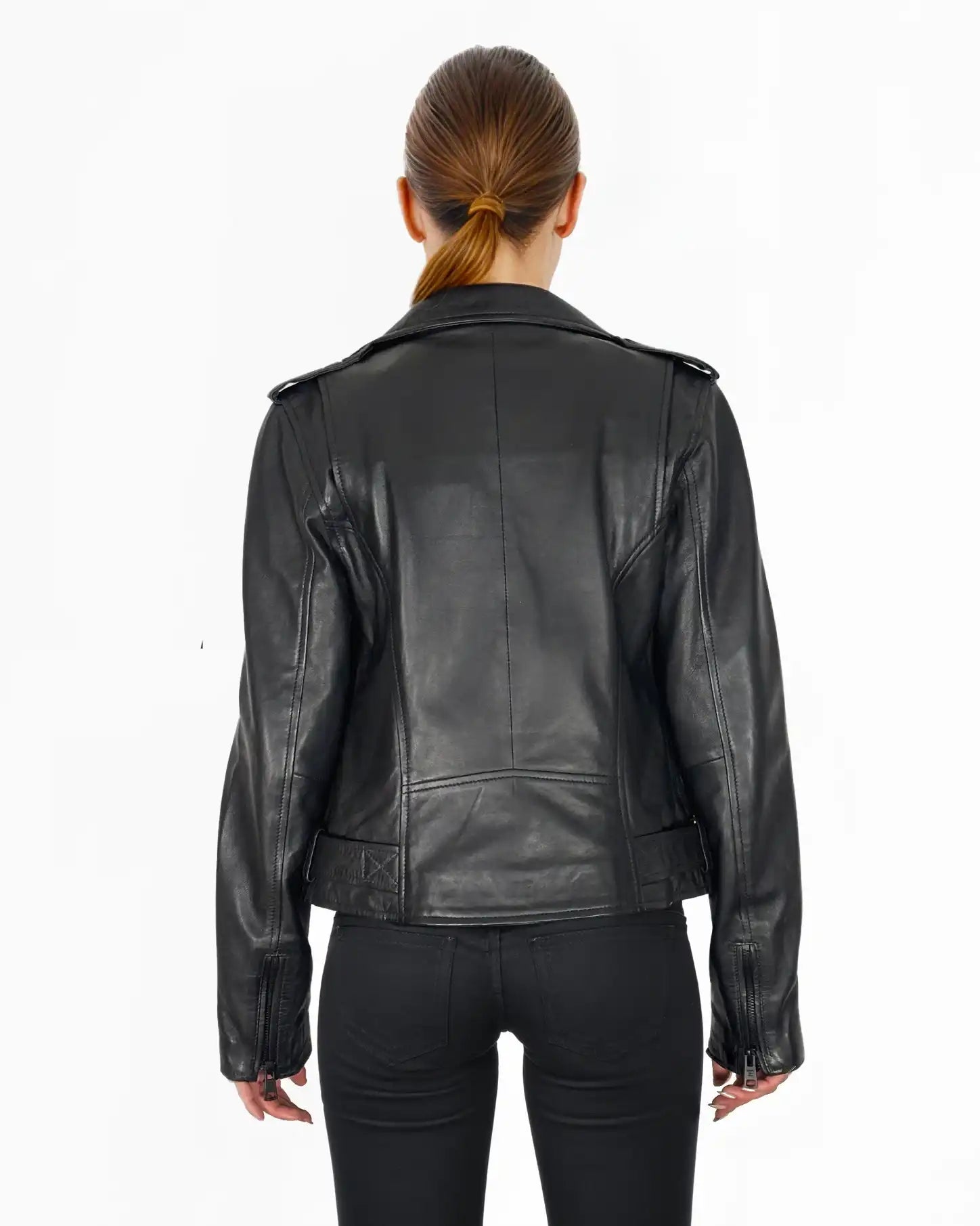 Eine Person mit braunen Haaren in einem niedrigen Pferdeschwanz wird von hinten gezeigt. Sie trägt eine trueprodigy Laura Feminine Bikerjacke mit Gürtel & Schulterriegeln und eine schwarze Hose vor einem schlichten weißen Hintergrund.