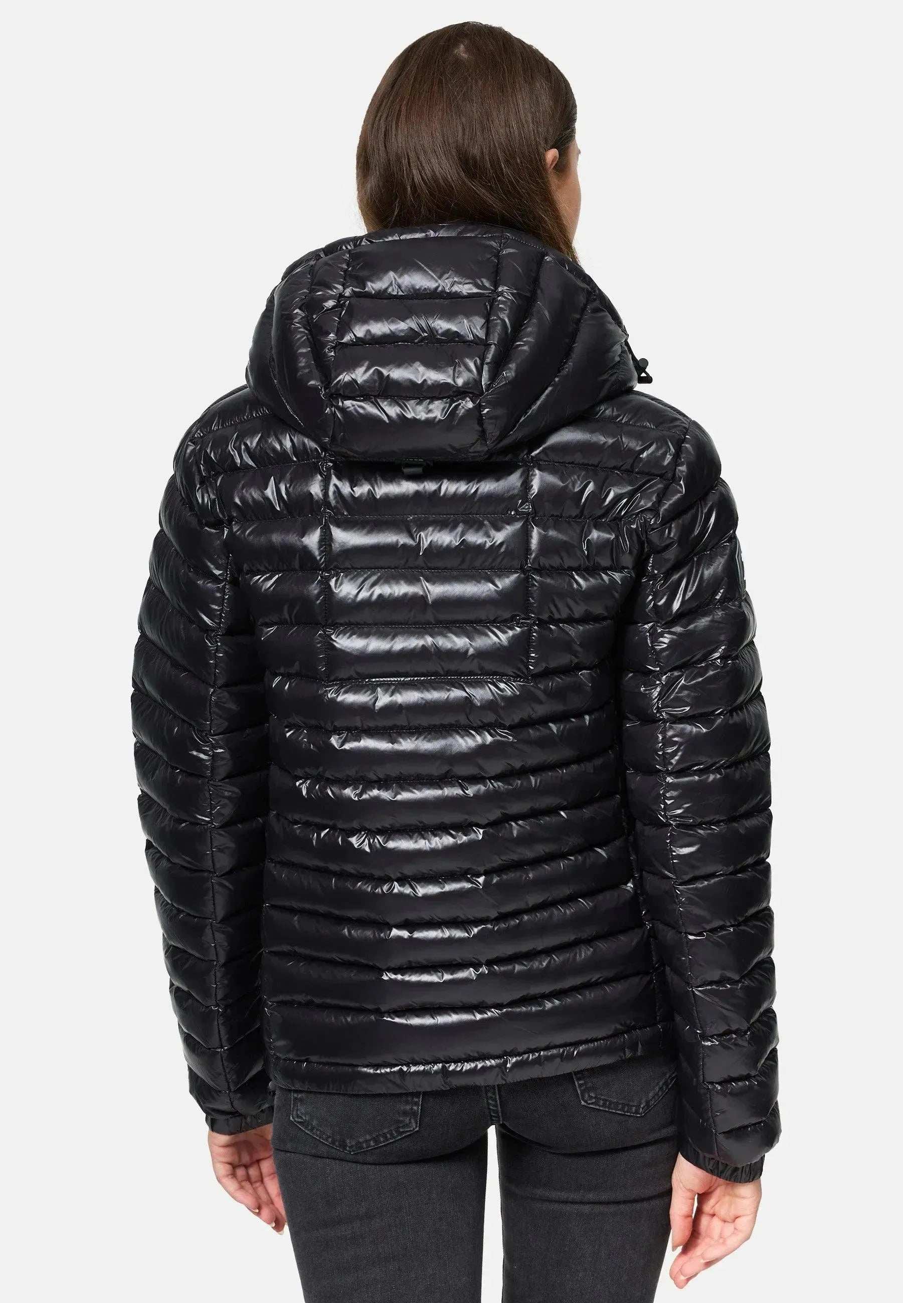 Eine Person trägt die Steppjacke mit Kapuze von trueprodigy Adan F, eine schwarze, glänzende Steppjacke mit horizontalen Nähten. Mit dem Rücken zur Kamera kombiniert sie dunkle Jeans vor einem schlichten weißen Hintergrund.