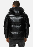 TRUEPRODIGY constance schwarze Pufferjacke mit glänzendem Finish, Kapuze. Rückansicht eines Mannes in urbanem Stil. Wintermode, hochwertiges Material, Streetwear-Look.