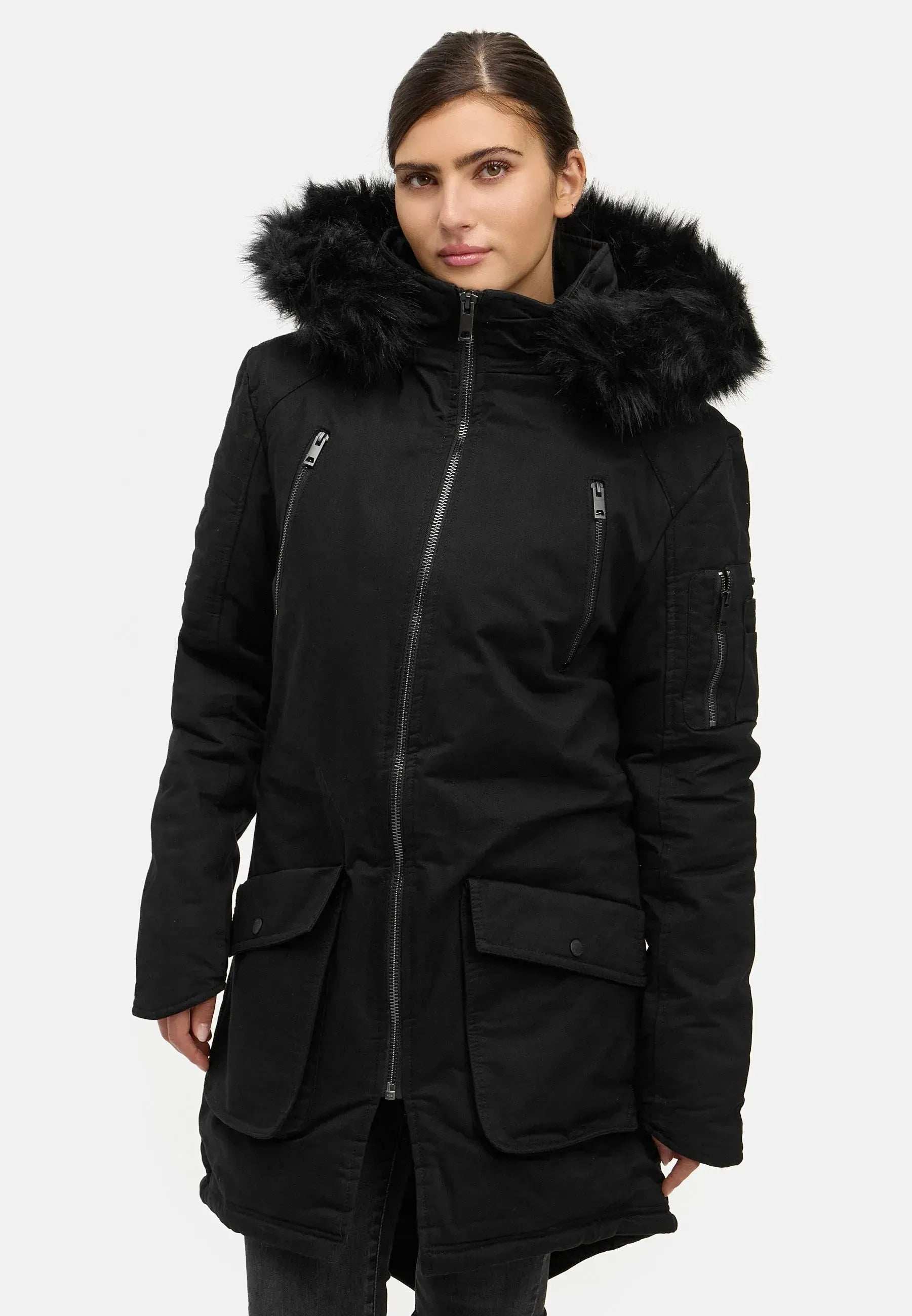 Eine Person trägt den schwarzen Damenparka Harvey F von trueprodigy mit Kapuze und Kunstfell, einen Wintermantel mit Kapuze, Frontreißverschluss, Pattentaschen und Brusttaschen mit Reißverschluss. Die Kapuze ist hochgezogen, während sie vor einem schlichten weißen Hintergrund steht.