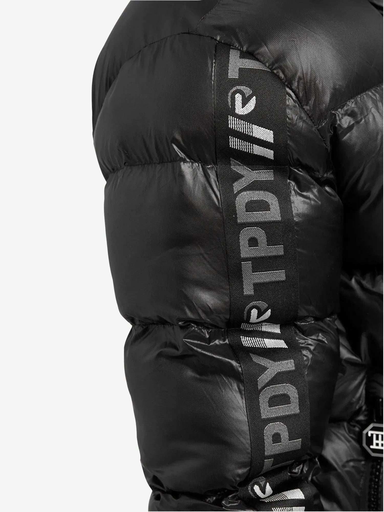 Nahaufnahme einer bauschigen schwarzen Logan Pufferjacke mit Logo von trueprodigy, mit „TPDY“-Text und Logo auf dem Ärmel. Diese wattierte Jacke hat glänzenden, gesteppten Stoff für Wärme und die Logan-Silhouette bietet einen eleganten Look vor einem schlichten weißen Hintergrund.