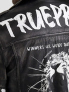 Nahaufnahme der Russell Lederjacke mit Print von trueprodigy, mit weiß gemaltem Text auf schwarzem Leder. Oben steht „TRUEPR“, darunter „WINNERS USE WORDS THAT“, mit einer Grafik eines brüllenden Löwen, überlagert mit „DO IT LIKE 100% SKILLS“. Fügen Sie noch einen kantigen Biker-Look hinzu.